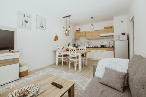 a kitchen and a living room with a couch and a table at Apartament Kraju centrum z fotelem masującym in Sosnowiec