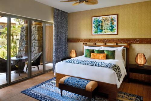 a bedroom with a large bed and a balcony at Lapita, Dubai Parks and Resorts, Autograph Collection in Dubai