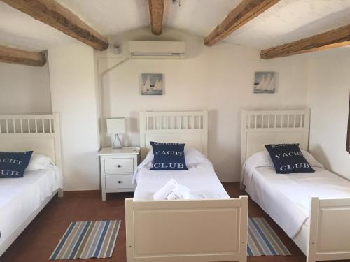 2 Betten in einem Zimmer mit weißen Wänden und Holzböden in der Unterkunft Casa Trastulli in Castelfrentano