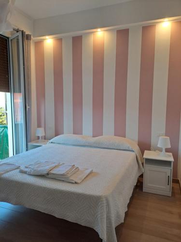 una camera da letto con letto a righe rosa e bianche di Ca di Ale a Lerici