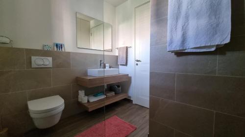 ein Badezimmer mit einem WC, einem Waschbecken und einem Spiegel in der Unterkunft Lustica Lux in Tivat