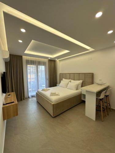 a bedroom with a large bed and a table and a desk at Studio Apartman Dalia in Budva