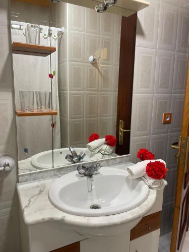 a bathroom with a white sink and a mirror at Playa Y Cañas in Noja