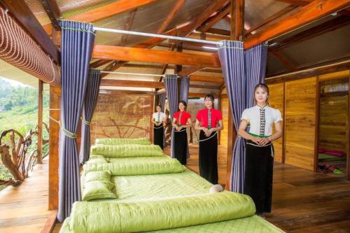 a group of people standing in a room with green beds at Homestay view núi cực đẹp in Cham Ta Lao