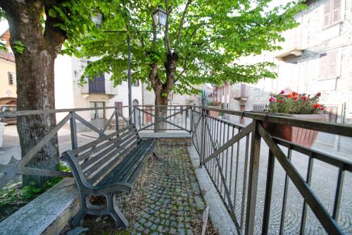 a park bench next to a fence with a tree at HONEY HOME Ponzone in Ponzone