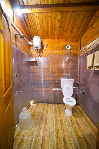 a bathroom with a toilet in a wooden ceiling at Casa De Silver in Baga