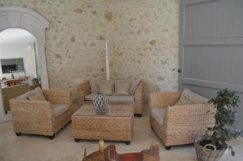 a living room with wicker chairs and a table at la cabanne in Saint-Martin-Lacaussade