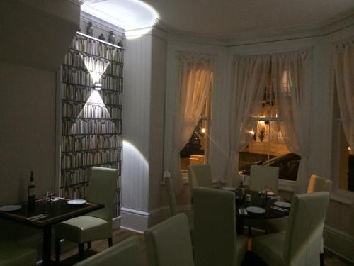 a dining room with tables and chairs and a window at The Prince Guest House in Great Yarmouth
