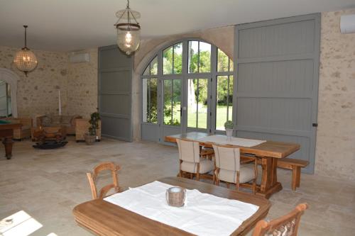 a living room with a table and chairs and a dining room at la cabanne in Saint-Martin-Lacaussade