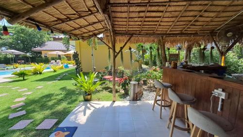 a patio with a bar with a view of a yard at Residence M Thailand, Resort, Mae Ramphueng Beach, Ban Phe, Rayong, Residence M Thailand in Ban Chamrung