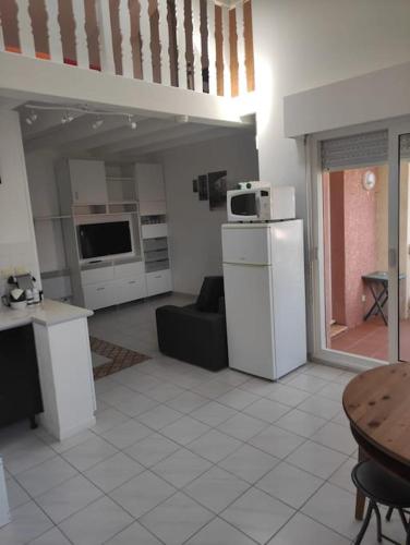 Il dispose d'une cuisine et d'un salon avec un réfrigérateur et une table. dans l'établissement Appartement proche mer, à Six-Fours-les-Plages