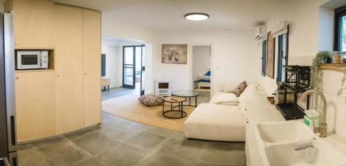 ein Wohnzimmer mit einem weißen Sofa und einem Tisch in der Unterkunft אחוזת אבירי הגליל in Sheʼar Yashuv