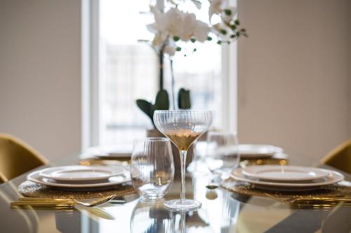 倫敦的住宿－Marble Arch Suite 4-Hosted by Sweetstay，桌子,桌子上放着玻璃杯和盘子,花瓶