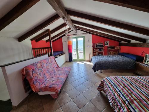 een slaapkamer met rode muren en een bed en een bank bij Casa Monte Bracco in Rifreddo