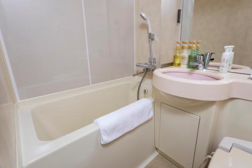 a bathroom with a sink and a toilet and a bath tub at Business Inn Norte in Sapporo