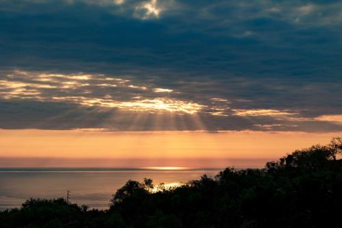 a sunset with the sun shining through the clouds at Halatsogiannis Mansion in Palaios Panteleimon