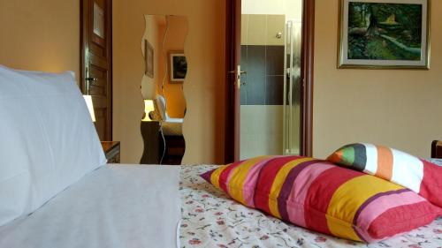 a bedroom with a bed with colorful pillows on it at B&B L'Aquila in LʼAquila