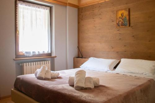 een slaapkamer met een bed met handdoeken erop bij Al Mughetto in Auronzo di Cadore