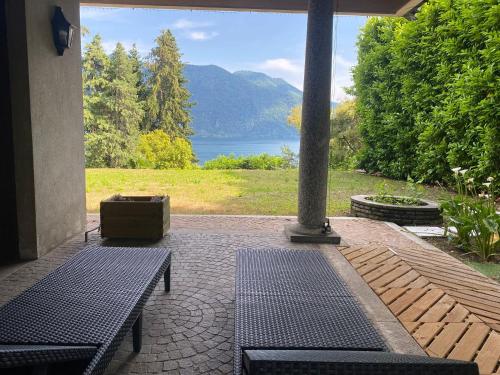 a patio with two benches and a view of a lake at Villa Rivabella - By Impero House in Ghiffa