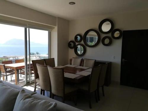 a dining room with a table and chairs and mirrors at Ponto Horizonte Manzanillo. Best place in Manzanillo!!! Luxury beach front condo, gorgeous views!! Best place you can stay!with up to 8 people. in Manzanillo