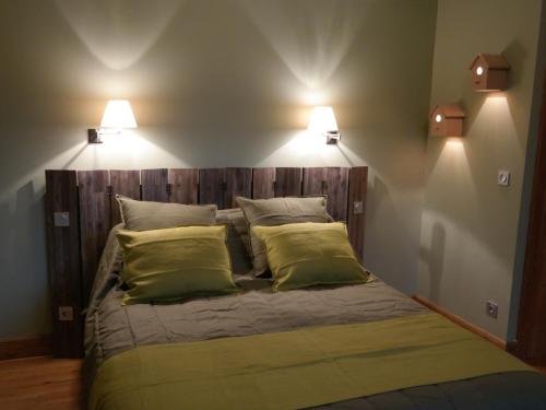 una camera da letto con un grande letto con due luci sul muro di Au Moulin des Fées - Maison d'hôtes Cascades du Hérisson a Bonlieu
