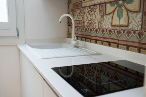 a white sink in a kitchen with a tap at Butiko in Castelluzzo