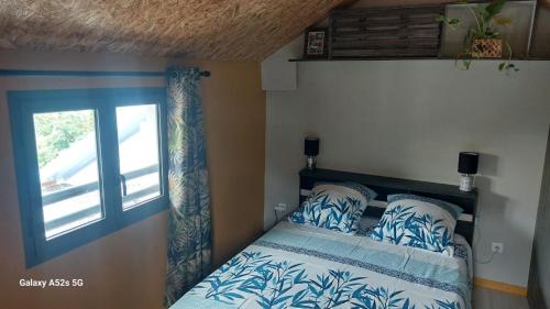 Schlafzimmer mit einem Bett und einem Fenster in der Unterkunft RÊV BOR D'MER in L'Étang-Salé-les-Bains