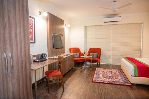 a hotel room with a bed a desk and a tv at La Oasis by Meraden ,Goa in Anjuna