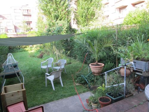 un patio trasero con un jardín con sillas y plantas en Merxotio en Ghent