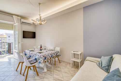 - une salle à manger avec une table et un canapé dans l'établissement Bedo House Beach Front - Happy Rentals, à Follonica
