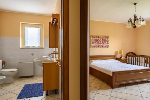 1 Schlafzimmer mit einem Bett und einem Bad in der Unterkunft La Collina degli Ulivi in Bari Sardo