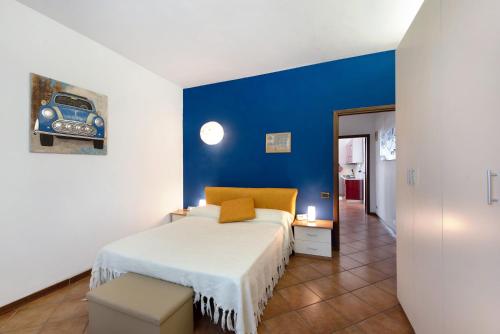 1 dormitorio con cama y pared azul en Beautiful Tagliolo, en Tagliolo Monferrato