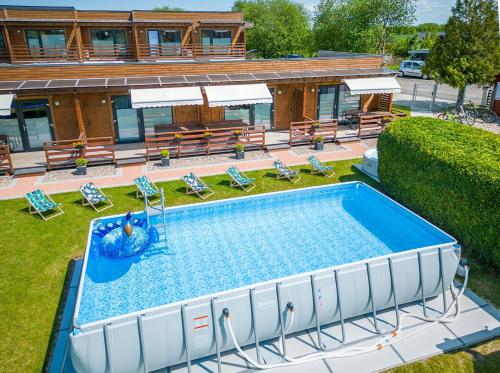 una vista aérea de una piscina con sillas y un edificio en Baltic Resort, en Mielno