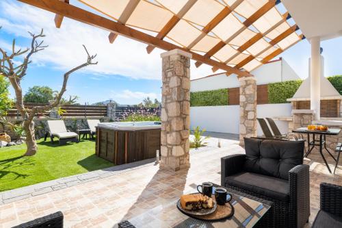 an outdoor patio with a table and chairs and a pergola at Casa Bonita Afandou in Rhodes Town