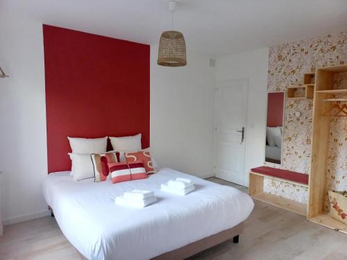 um quarto com uma cama branca e uma parede vermelha em Le Clos Beauséjour em Montjean-sur-Loire