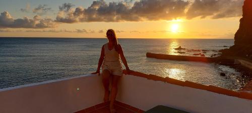 AlojeraにあるVv Puesta de Solの夕日を眺めながら腰掛けている女
