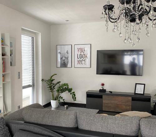 ein Wohnzimmer mit einem Sofa und einem TV in der Unterkunft Luxuriöses City Penthouse in Friedrichshafen