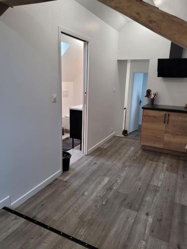 an empty room with a wooden floor and a living room at Appartement proche circuit in Changé