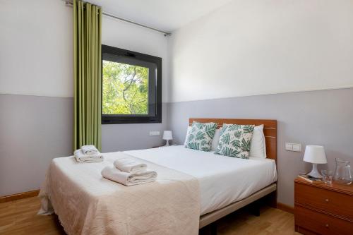 1 dormitorio con 1 cama con toallas en Apartments Sata Park Guell Area, en Barcelona