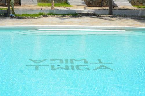 a swimming pool with a graffiti on the water at Twiga Beach Resort in Watamu