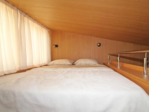 Schlafzimmer mit einem großen weißen Bett und Holzwänden in der Unterkunft BUNGALOVI AMFORA in Ljubuški