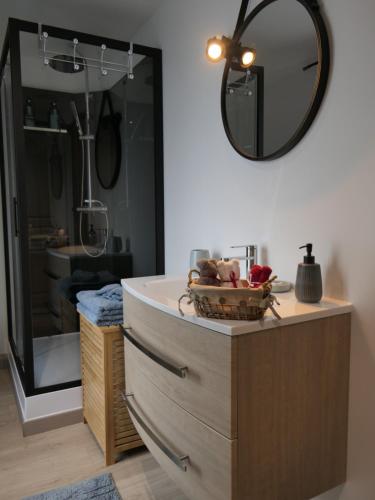 ein Badezimmer mit einem großen Spiegel und einer Kommode in der Unterkunft L'Escale des remparts in Rocroi