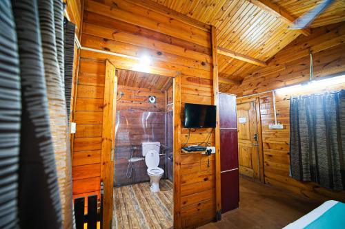 a bathroom with a toilet in a wooden cabin at Casa De Silver in Baga