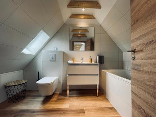La salle de bains est pourvue de toilettes, d'un lavabo et d'une baignoire. dans l'établissement Gîtes intemporels d'Alsace, à Wintzenheim