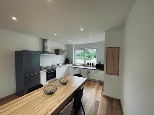 - une cuisine avec une table en bois et un comptoir dans l'établissement Gîtes intemporels d'Alsace, à Wintzenheim