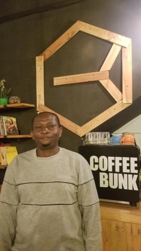 a man is standing in front of a coffee burner at CoffeeBunk Hostel in Tangerang