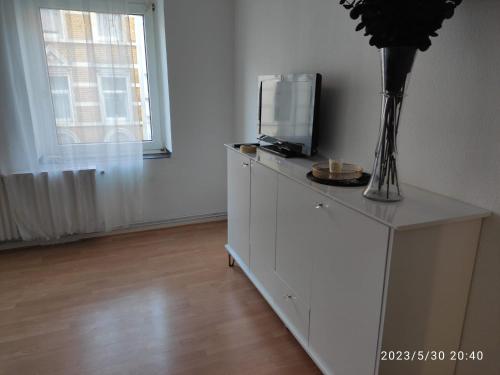 una cómoda blanca con una TV encima en 3 Zimmer Wohnung Zentrumsnähe en Aachen