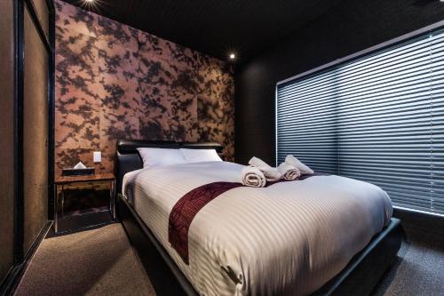 a bedroom with a large bed and a window at Shiki Homes HIGOYA 肥後屋 in Kyoto