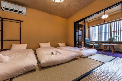 two beds are lined up in a room at Shiki Homes HIGOYA 肥後屋 in Kyoto