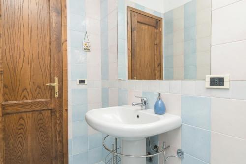 een badkamer met een witte wastafel en een spiegel bij La Gioia in Palau